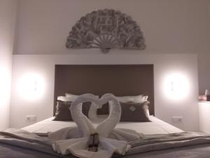 two swans are forming a heart on a bed at Seaview Guesthouse in Olhão