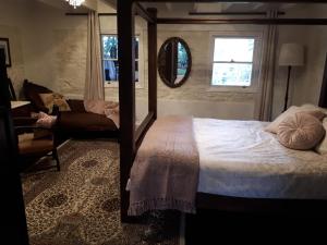 1 dormitorio con cama, silla y espejo en Tanilba House en Lemon Tree Passage