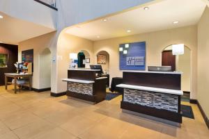 eine Lobby mit einem Friseursalon mit einem Laptop an der Wand in der Unterkunft Holiday Inn Express & Suites Southport - Oak Island Area, an IHG Hotel in Oak Island