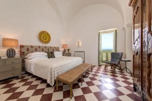 a bedroom with a bed and a checkered floor at Rocco Forte Masseria Torre Maizza in Savelletri di Fasano