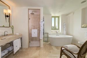 a white bathroom with a tub and a sink at Rocco Forte Masseria Torre Maizza in Savelletri di Fasano