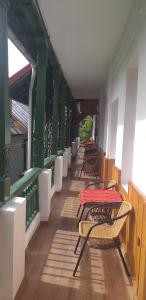 einen Balkon mit Tischen und Stühlen auf einem Gebäude in der Unterkunft Casa Olanescu in Băile Olăneşti