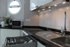 a kitchen with a sink and a microwave at Luxury Hotel Suite Terrace & Parking in Málaga