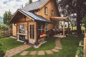 eine Holzhütte mit einer Veranda und einer Terrasse in der Unterkunft Luxus Ferienhaus Altaussee in Puchen