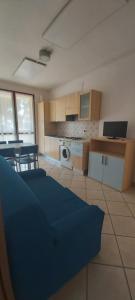 a kitchen with a blue bed in a room at Residence Leonardo in Lido di Spina