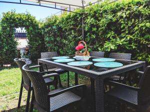 czarny stół z krzesłami i kosz kwiatów na nim w obiekcie Villa Carlini w mieście Passo Oscuro