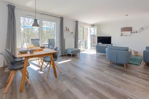 comedor y sala de estar con mesa y sillas en Ferienwohnung Vergissmeinnicht en Ostseebad Sellin