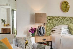 a bedroom with a bed and a table with flowers at Rocco Forte Masseria Torre Maizza in Savelletri di Fasano
