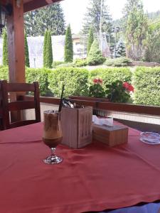 un tavolo con una bevanda su una tovaglia rossa di Azuga Ski & Bike Resort ad Azuga