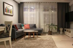 a living room with a blue couch and a table at Sopot, BIG APARTMENT FOR 6!!! Air condition, jacuzzi in Sopot