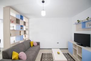 un soggiorno con divano grigio e TV di Apartament Alegria by Alz a Mamaia Nord - Năvodari