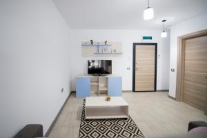 un soggiorno con un divano e una televisione di Apartament Alegria by Alz a Mamaia Nord - Năvodari