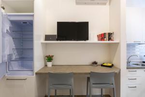 - une cuisine avec un comptoir avec deux chaises et un réfrigérateur dans l'établissement Yellow Line Apartment, à Milan