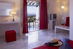 a living room with red curtains and a view of the ocean at Atrium of Alonissos in Patitiri