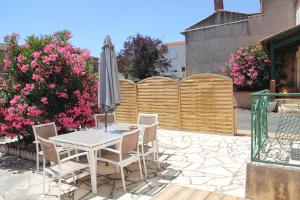 a table and chairs with an umbrella on a patio at La BLAUDIERE in Mouchamps