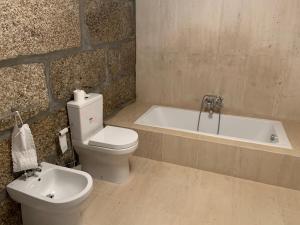 a bathroom with a toilet and a bath tub at Casa AURORA in Amarante