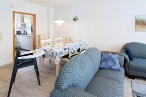 - un salon avec une table à manger et des chaises dans l'établissement Ferienhaus Kormoran, à Dornumersiel
