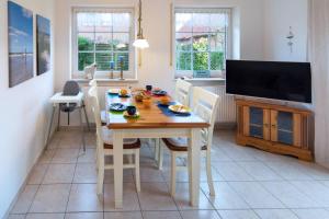 a dining room with a table with chairs and a television at Ferienhaus Strandruhe in Dornumersiel