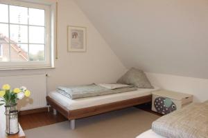 a small bedroom with a bed and a window at Ferienhaus Strandruhe in Dornumersiel