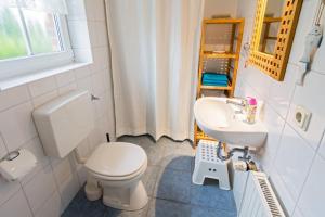 a bathroom with a toilet and a sink at Ferienhaus Strandruhe in Dornumersiel +21 photos