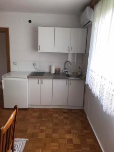 a kitchen with white cabinets and a sink at Sobe Lara in Gradačac