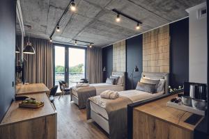 1 dormitorio con 2 camas y sala de estar en The Bridge Suites en Cracovia