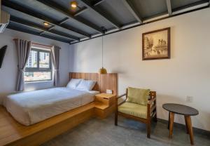 a bedroom with a bed and a chair and a table at Coast House Boutique Hotel in Nha Trang +37 photos