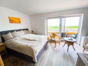 a bedroom with a large bed and a table and chairs at Appartmentanlage Zur Düne in Insel Poel