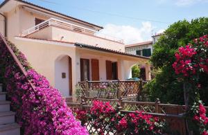 uma casa com flores cor-de-rosa em frente em Casa degli Agrumi em Pomonte