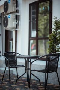 duas cadeiras e uma mesa em frente a um edifício em REEF Hotel em Koblevo