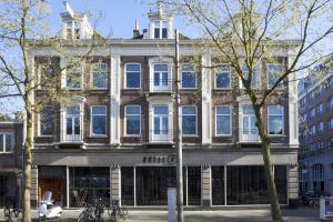 a large building on a city street with trees at V Lofts in Amsterdam