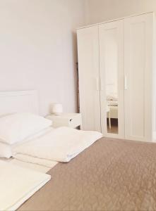 カリーニングラードにあるVerona апартаментыの白いベッドルーム(ベッド2台、鏡付)