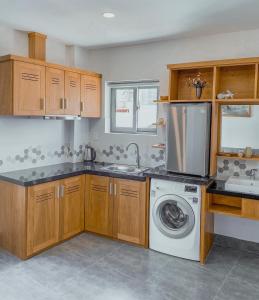 a kitchen with wooden cabinets and a washer and dryer at Coast House Boutique Hotel in Nha Trang