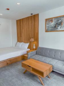 a living room with a couch and a bed at Coast House Boutique Hotel in Nha Trang