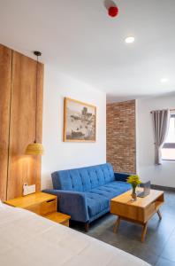 a living room with a blue couch and a table at Coast House Boutique Hotel in Nha Trang