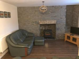 a living room with a couch and a fireplace at Rj s house in Merthyr Tydfil