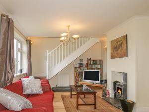 a living room with a red couch and a tv at Hebridean View in Trumpan