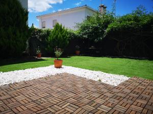 un jardín con un patio de ladrillo con rocas blancas en Aracena Suites, en Aracena