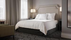 ein Schlafzimmer mit einem großen Bett mit weißen Laken und Kissen in der Unterkunft Hotel Victoria in Stavanger + 42 Fotos