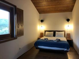 ein Schlafzimmer mit einem Bett mit zwei Schuhen drauf in der Unterkunft Quinta do Ragal in Lavacolhos