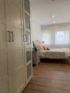 a bedroom with a bed and a large sliding door at Apartamento céntrico y moderno in Ferrol