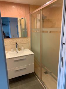 een badkamer met een douche, een wastafel en een spiegel bij Apartment Puerto ALCUDIA in Port d'Alcudia