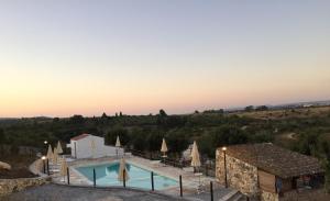 eine Villa mit Swimmingpool und einem Gebäude in der Unterkunft B&B Badde Cubas in Usini