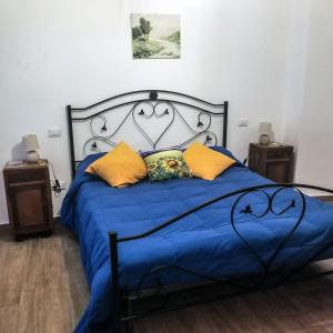 a bedroom with a blue bed with yellow pillows at B&B La casa dei nonni in San Donato Val di Comino
