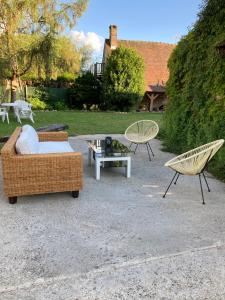 a patio with two chairs and a couch and a table at Villa Nymphea in Saint-Pierre-dʼAutils