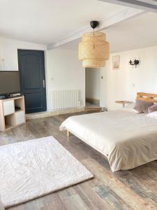 a bedroom with a large white bed and a table at Villa Nymphea in Saint-Pierre-dʼAutils