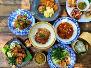 a group of plates of food on a wooden table at PAN KLED VILLA eco hill resort in Chiang Rai