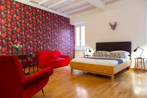 una camera con letto e sedia rossa di Paglia House of 17Century in Trastevere a Roma