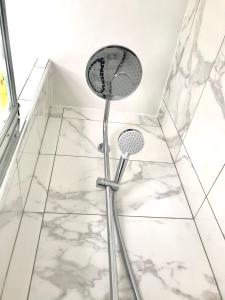 a shower in a bathroom with white tiles at Residence Hoche in Le Pré-Saint-Gervais