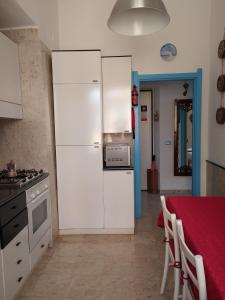 ヴェルナッツァにあるAgretta Sea View Apartmentのキッチン(白い冷蔵庫、テーブル付)
